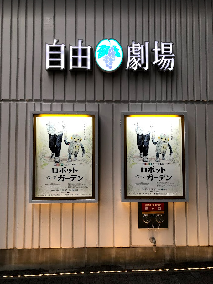 自由劇場エントランスの自由劇場ロゴと、ミュージカル『ロボット・イン・ザ・ガーデン』の公演ポスター2連