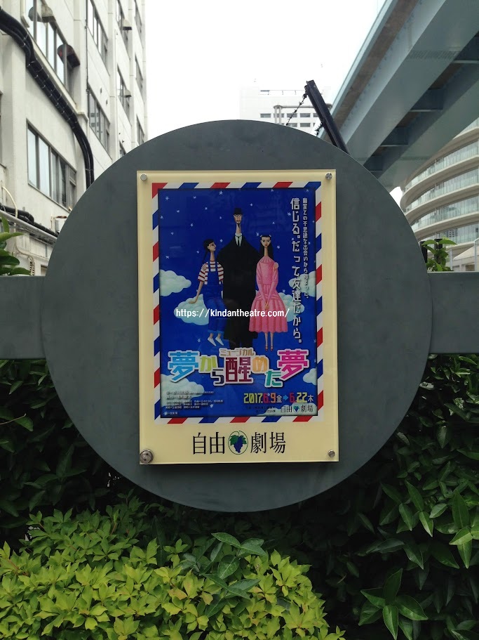 自由劇場の円形看板に掲示されたミュージカル『夢から醒めた夢』のポスター画像