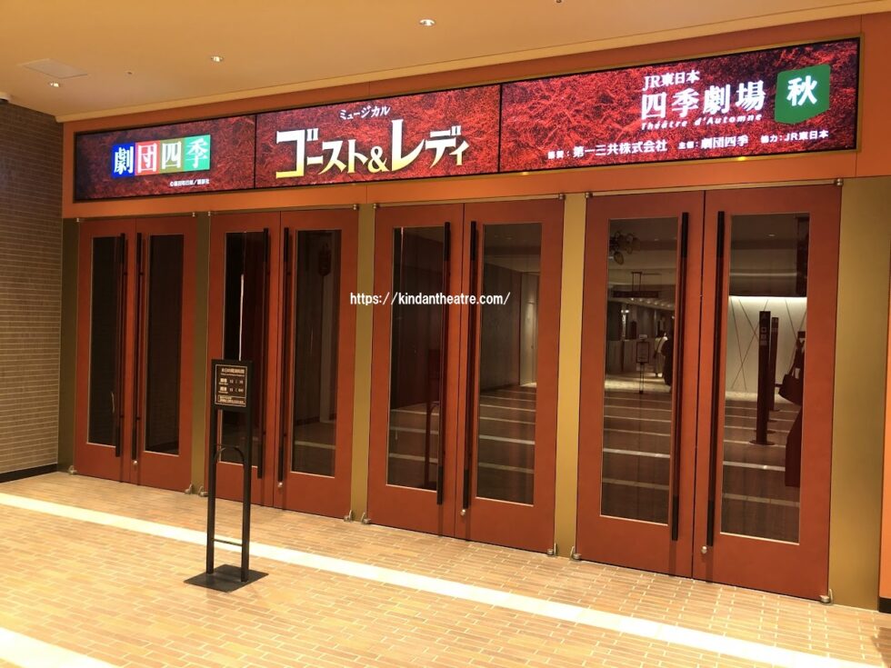 世界初演が行われたJR東日本四季劇場［秋］の正面玄関と、ゴースト＆レディの電光掲示板
