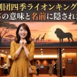 劇場のロビーでワクワクした表情を浮かべる女性と、背後に広がるサバンナの壁画。「劇団四季ライオンキング！シンバの意味と名前に隠された秘密」のテキスト入りアイキャッチ画像