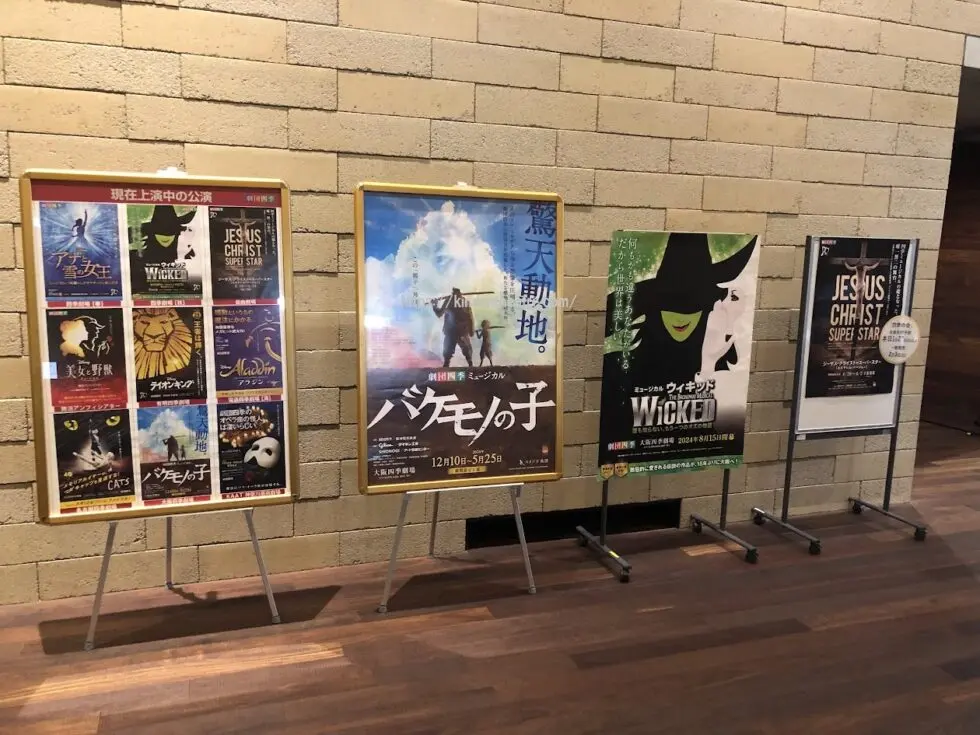 豊中市立文化芸術センターのロビーに掲示示された、劇団四季の現在上演中の公演ラインナップや全国ツアーのポスター群