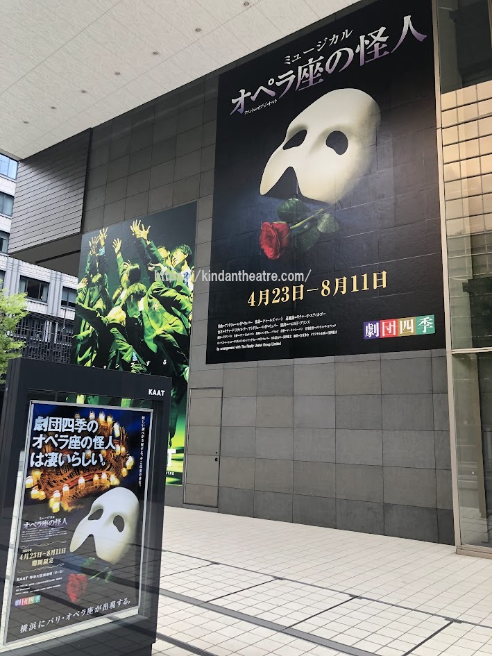 KAAT神奈川芸術劇場の外壁に掲示された劇団四季ミュージカル「オペラ座の怪人」の白い仮面と赤い薔薇が描かれた超大型ポスター