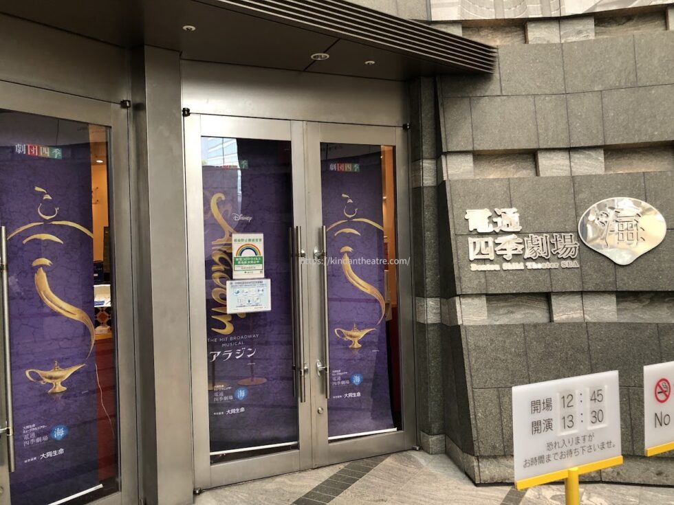 ミュージカル『アラジン』のポスター装飾が施された電通四季劇場［海］の入り口扉と案内板