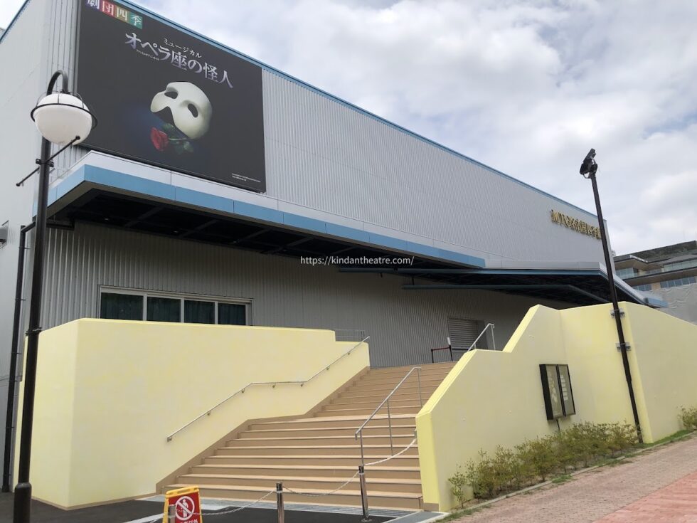 ミュージカル『オペラ座の怪人』の看板が掲げられたMTG名古屋四季劇場の外観と階段