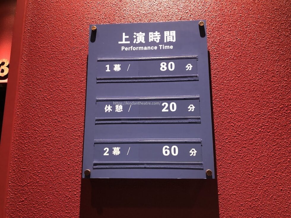 劇団四季劇場内の赤い壁に設置された1幕・休憩・2幕の『オペラ座の怪人』上演時間案内ボード（MTG名古屋四季劇場）